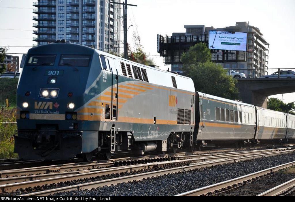 Eastbound passenger train cruises past the station